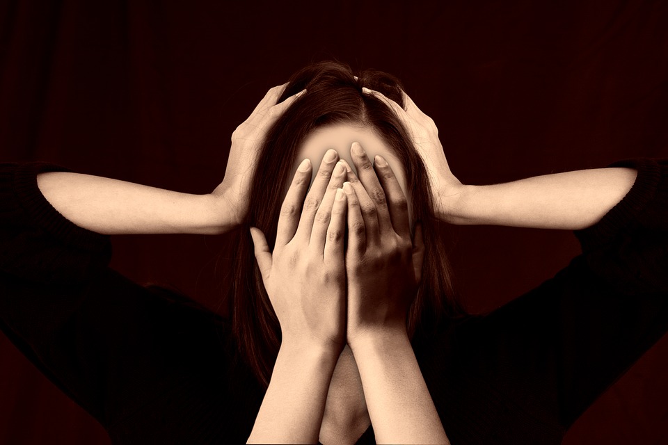 Worrying woman covering her face with a second set of hands on her head